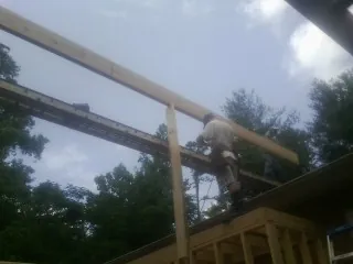 Carpenter setting a ridge beam over a new addition frame — Ice Dam Removal by Roofing Brothers in Bruno