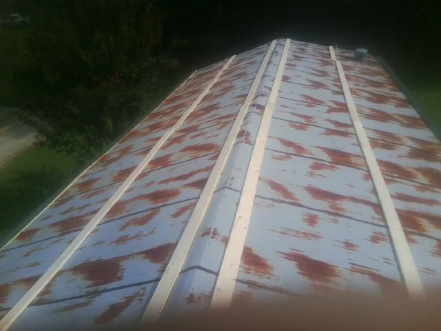 Rusted metal roof panels with new wood purlins before replacement — Storm Damage Roof Repair in Bruno by Roofing Brothers