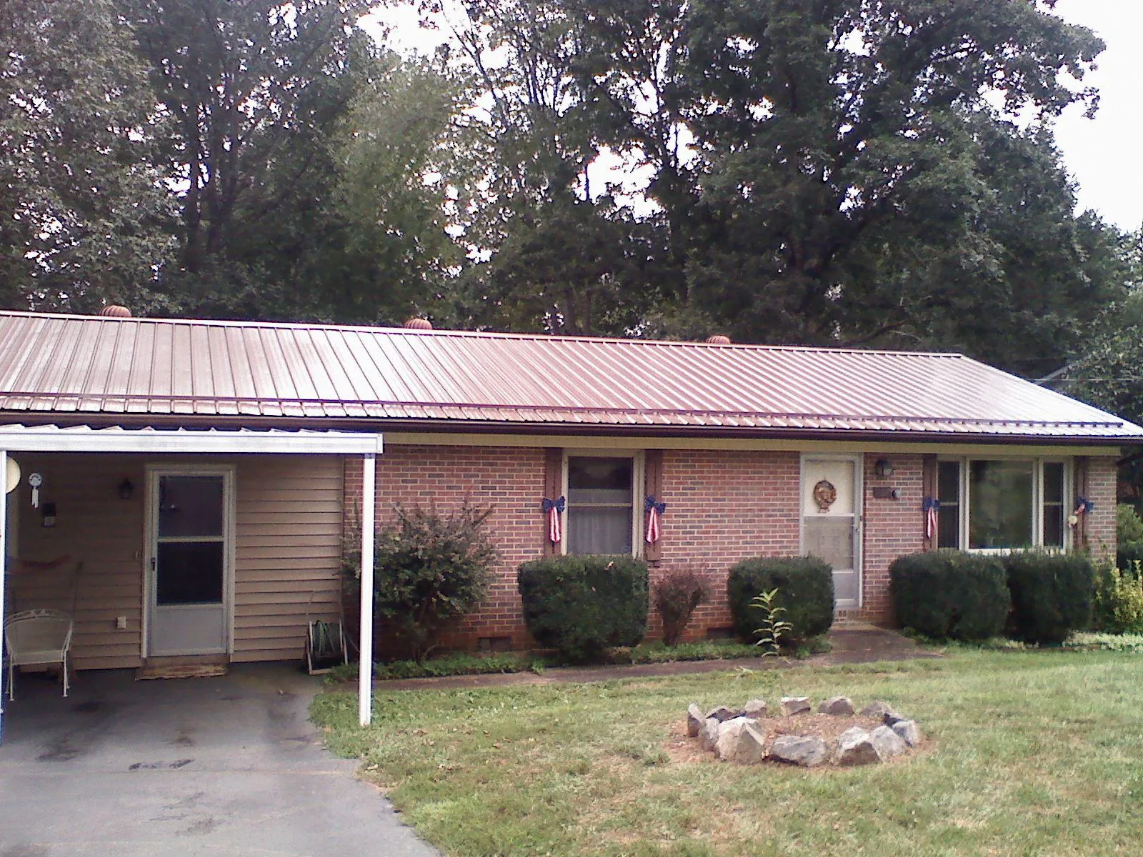 Bronze metal roof and carport on a brick ranch home — Roof Repair work by our crew in Bruno